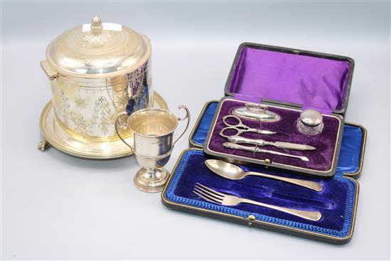 A plated biscuit barrel and a silver trophy cup and a manicure set etc